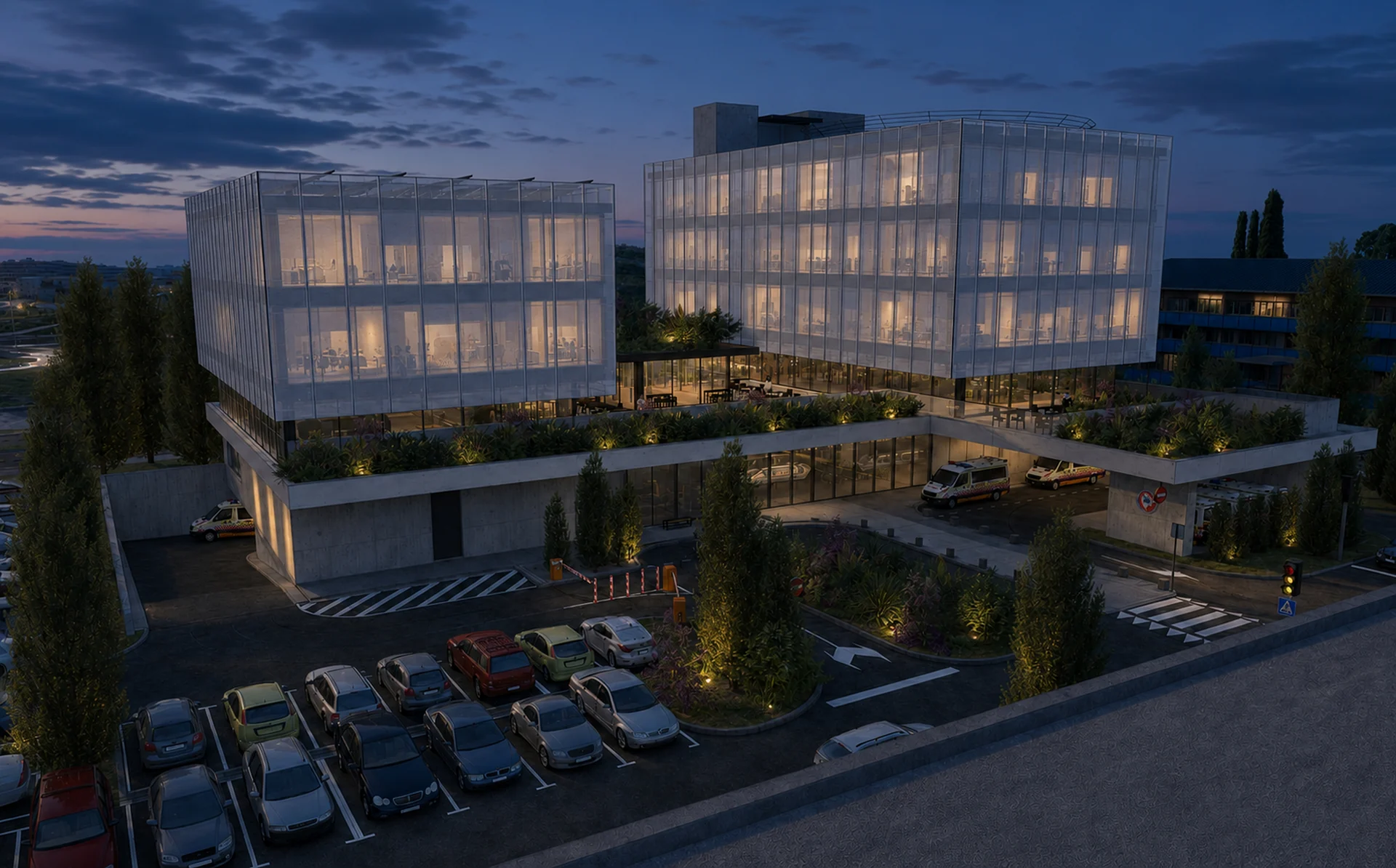 The complex at dusk — transparent ground floor and illuminated screens